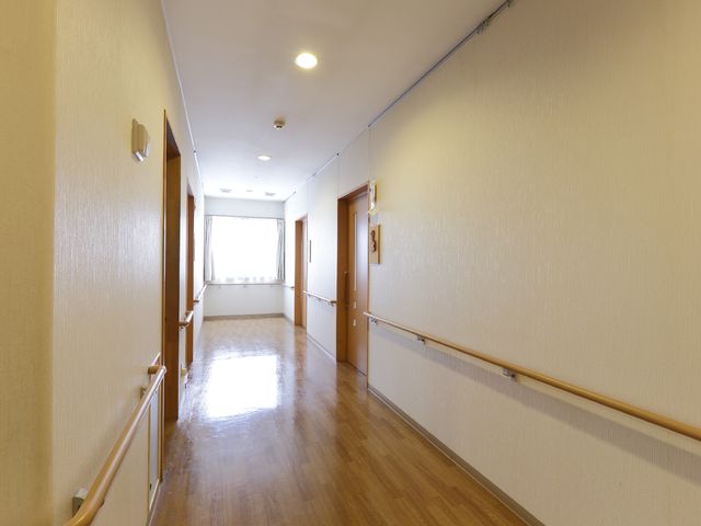 明るい廊下 廊下 柔らかな光が差し込む清潔な通路。手すりは歩行の支援に役立ちます。