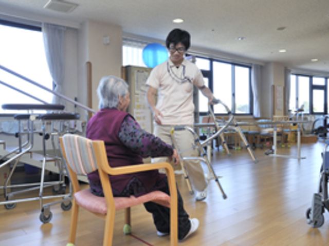 明るい室内の機能訓練室 機能訓練室   広々とした空間で、介護職員が利用者のサポートを行っています。働きやすい環境です。
