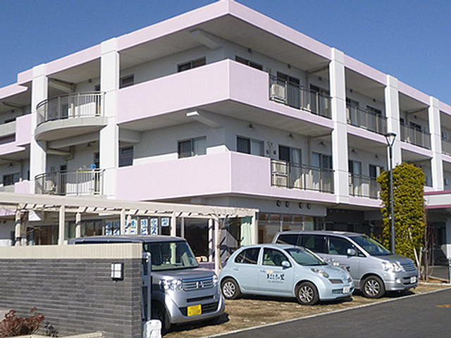 三階建ての外観 外観 清潔感のある三階建ての建物で、明るい色使いが印象的です。駐車スペースも完備されています。