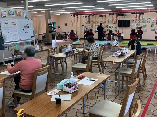 トレーニング中の部屋 機能訓練室 自然光が差し込む広々とした空間で、リハビリが行われています。和やかな雰囲気で会話が弾む場です。