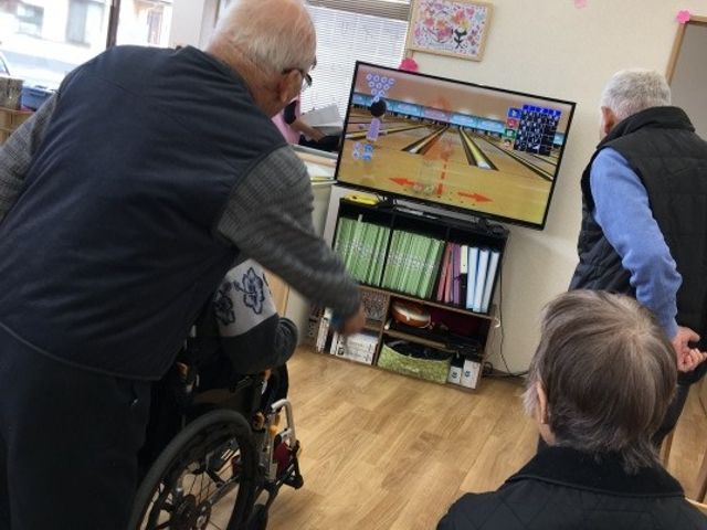 ゲーム楽しむ人々 機能訓練室 広々とした空間で、ゲームを通じて楽しくリハビリが行えます。皆さんで和やかに交流できます。