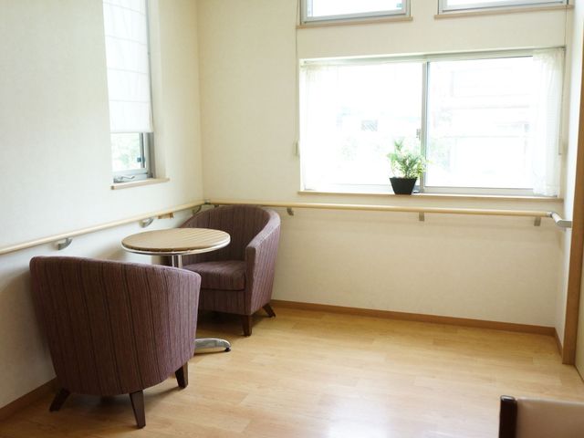 リラックスできる居室空間 談話室 ゆったりとした椅子が置かれた明るい居室です。一息つきながら、外の景色をお楽しみいただける環境が整っています。