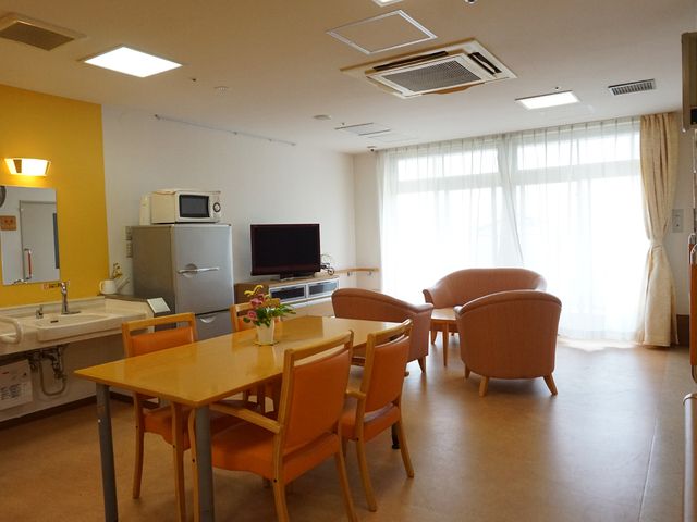 共有スペースのリビング リビング ゆったりとした椅子とダイニングテーブルが配置され、日の光が差し込む温もりのある空間です。共有スペースでのんびりと時間を過ごせる環境が整っています。