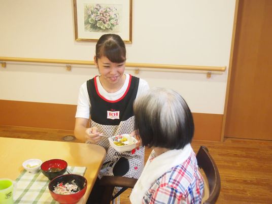 笑顔で食事介助をするシーン