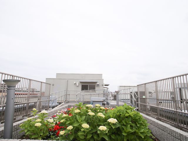 屋上の花壇と手すり 屋上 開放的な屋上テラスで、季節の花々に囲まれたやすらぎの時間を過ごせます。新鮮な空気と共にリフレッシュしてください。