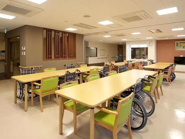 食堂の広いテーブル配置 食堂   ゆとりのあるテーブル配置で、車椅子の方も移動しやすい食堂です。明るい照明の下で、落ち着いて食事の準備ができそうです。