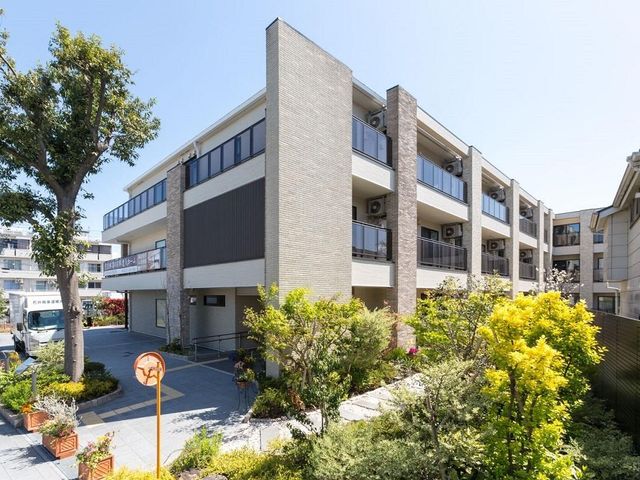 明るい庭付き建物外観 外観 緑豊かな庭を備えた落ち着いた雰囲気の建物です。快適な環境での就業をお求めの方に適しています。