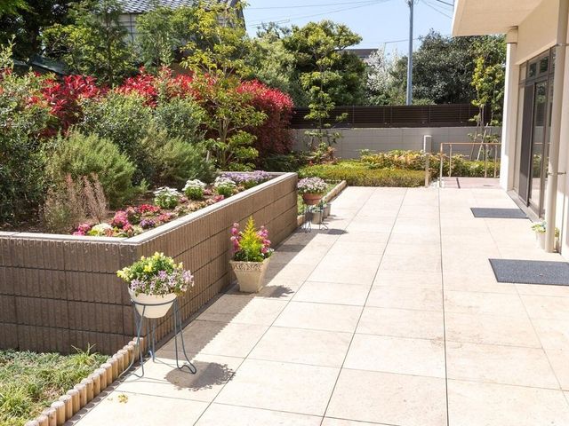 中庭の緑と歩道 庭園 四季折々の花々に囲まれた、ゆったりとした時間が流れる中庭です。散策や休憩に最適な開放的なスペースが広がっています。