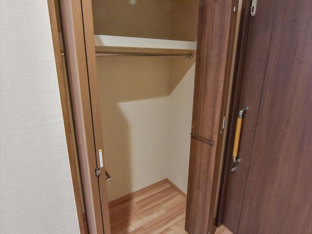 茶色い扉を開けたクローゼット 収納 収納力のあるクローゼットが完備されており、快適に過ごしていただける空間を提供しています。
