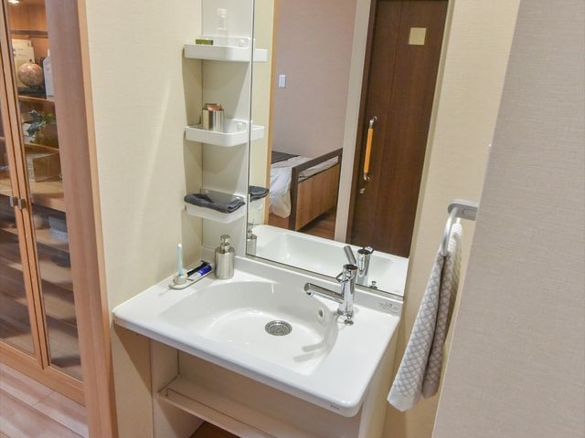 清潔な洗面台とミラー 洗面台 シンプルで使いやすい洗面スペースです。手入れが行き届いており、日々の快適な生活をサポートします。