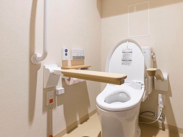 バリアフリー設計のトイレ トイレ 手すり付きの清潔なトイレは、安全に配慮した作りです。利用しやすい工夫が施された、快適な空間を提供しています。