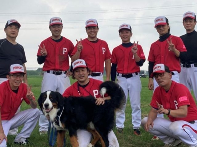 チームのメンバーと犬 スタッフイメージ チームワークの良さや親しみやすさが感じられるスタッフの集合写真です。