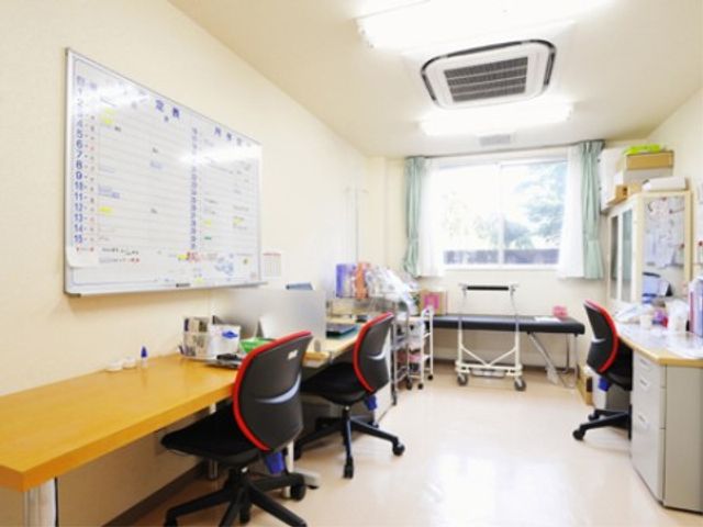 スケジュールが記された事務室 健康管理室 整理整頓された事務室で、スタッフ間のコミュニケーションも取りやすい環境です。明るい窓から自然光が差し込み、作業に集中しやすい空間となっています。