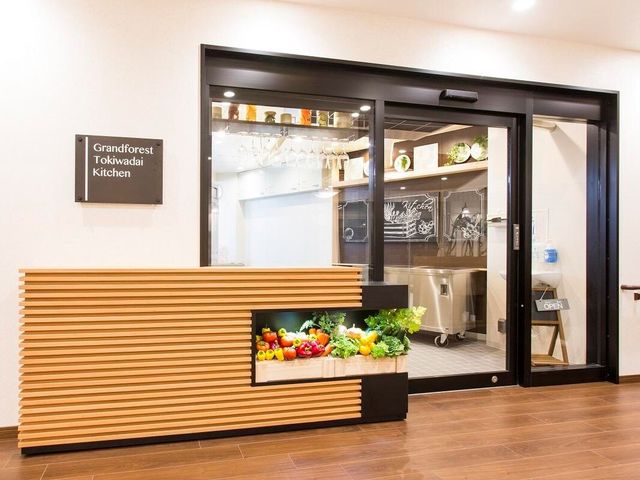 キッチン入口と野菜のディスプレイ オープンキッチン 清潔感のあふれるキッチン入口は、ご家族の訪問時にも安心の開放的な印象です。新鮮な食材を用いたお食事の提供に努めています。