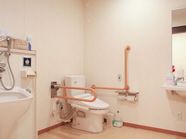 バリアフリーの洗面台とトイレ トイレ ゆとりあるスペースのトイレには、安心の手すりが設置され、快適な使用が考慮されています。