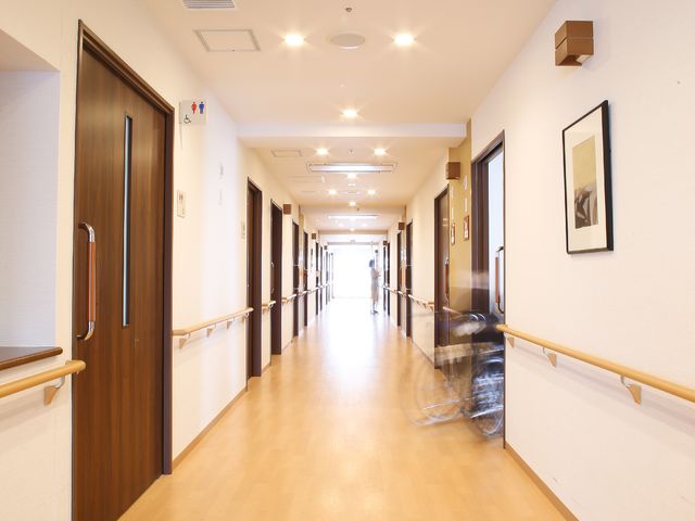 清潔で広々とした廊下 廊下 手すり付きの廊下を歩きやすく、清掃が行き届いて明るい雰囲気です。訪れる方々への配慮が感じられます。