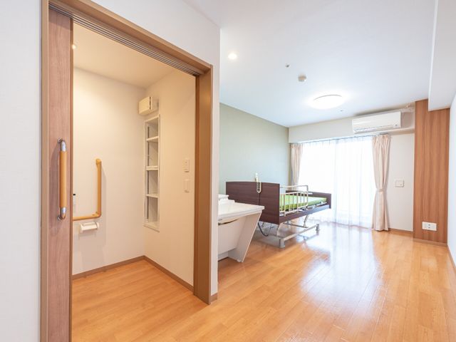 居室のゆったり空間 居室 床は木目調で暖かみのある広々とした部屋です。設備も整い、快適そうな空間が広がっています。