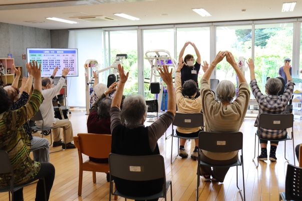 椅子に座る人々とスタッフ