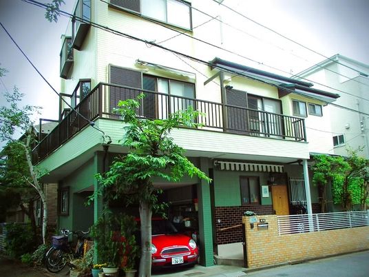 緑に囲まれた三階建て外観