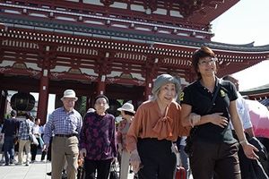 散歩する高齢者とスタッフ