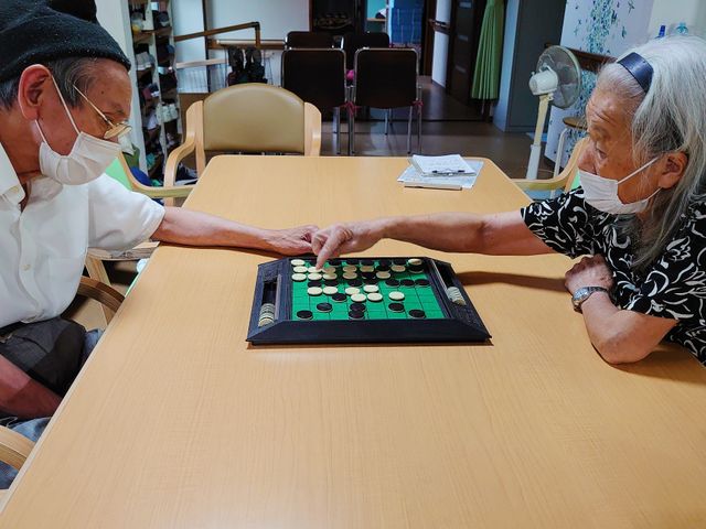 将棋を指す高齢者 和やかな雰囲気の共有スペースで、入居者同士が将棋を楽しむ様子です。リラックスした時間を過ごしながら交流を深めることができます。