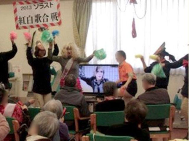 楽しいイベントの様子 レクリエーション 利用者の皆様が楽しそうにイベントに参加されており、笑顔で手を振る姿が見られます。共有空間での交流が、日々の生活に彩りを与えています。