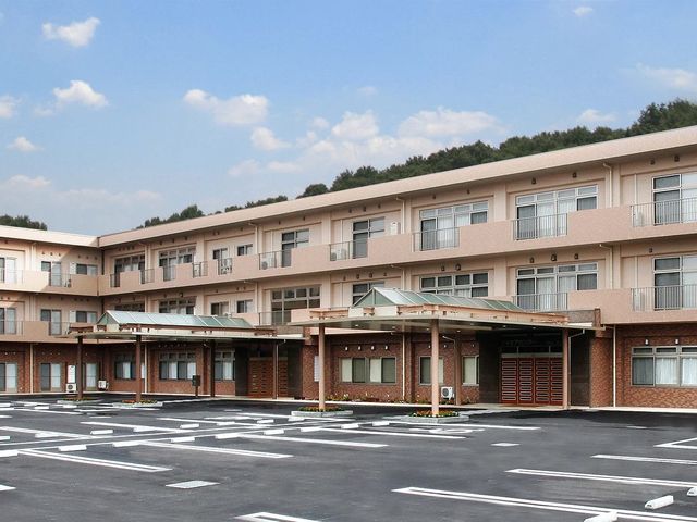施設の外観 外観   落ち着いた色合いの建物で、2階の窓やバルコニーが並んでいます。広い駐車スペースがあり、出入りしやすそうです。