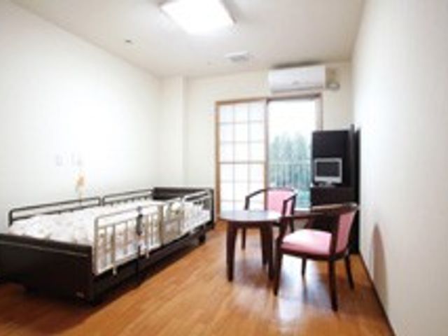 明るい木製の居室 居室 自然光が差し込むこの部屋は、落ち着いた木の床が特徴で、快適な環境を提供します。