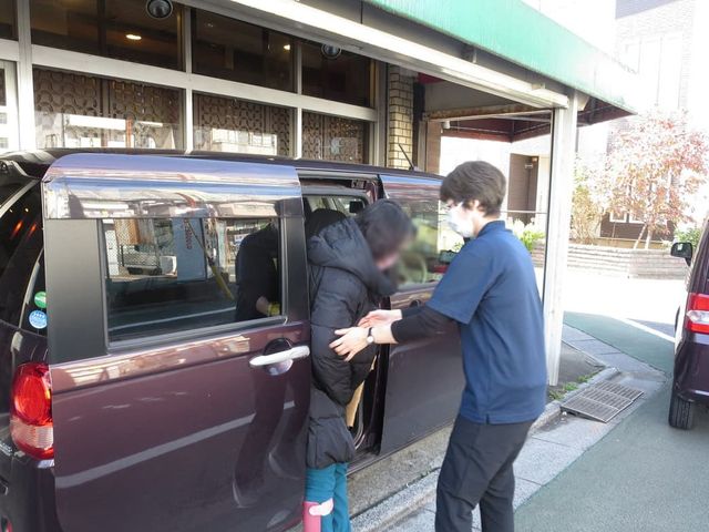 車両乗降支援様子 外観 スタッフが安全に配慮しながら、利用者の方の乗降サポートを行っています。運転のしやすい車両が使用されています。
