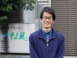 笑顔のスタッフと看板