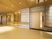 サムネイル 施設の写真 ダウンライトが優しく照らす広々とした廊下。壁には、木でできた幅の広いタイプの手すりが設置されている。