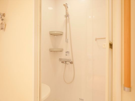 居室内にはシャワールームが備わっている。シャワーの脇にはコーナーラックやタオル掛けが取りつけられている。