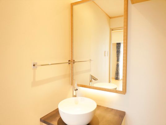居室にある洗面台の一例である。洗面ボウルが机に載っているような個性的なデザインで、鏡も木枠のついたおしゃれなものが設置されている。