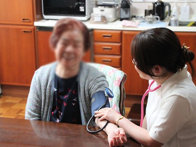 笑顔のシーンの一部 スタッフイメージ 広々としたリビングで、スタッフが親身に利用者をケアしています。温かい雰囲気が感じられます。