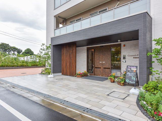 モダンなデザインのエントランス 外観 温かみのある木目調でまとめられたエレガントなエントランス。訪れる全ての方を暖かくお迎えします。