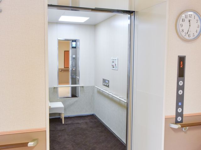 清潔なエレベーター入口 エレベーター 安全かつスムーズに移動ができるエレベーターで、快適な勤務環境が整っています。壁には掲示物があり、情報共有も円滑です。
