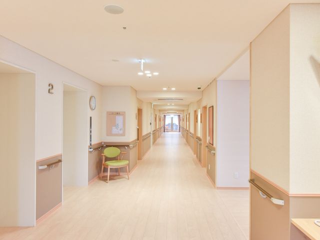 清潔な廊下の一角 通路 手すりが設置された広々とした廊下です。明るくゆったりした通路は、快適な移動を支援しています。