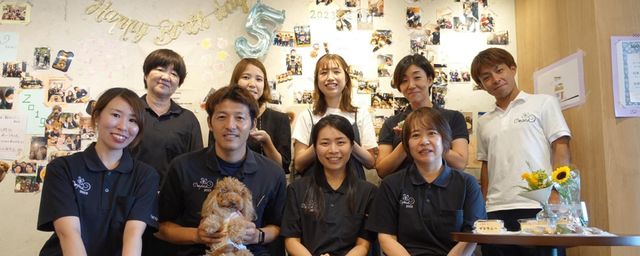 笑顔のスタッフたちと犬の集まり