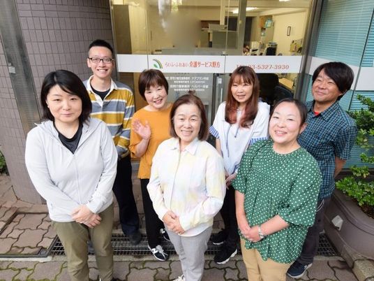 笑顔のスタッフが並ぶ外観前  