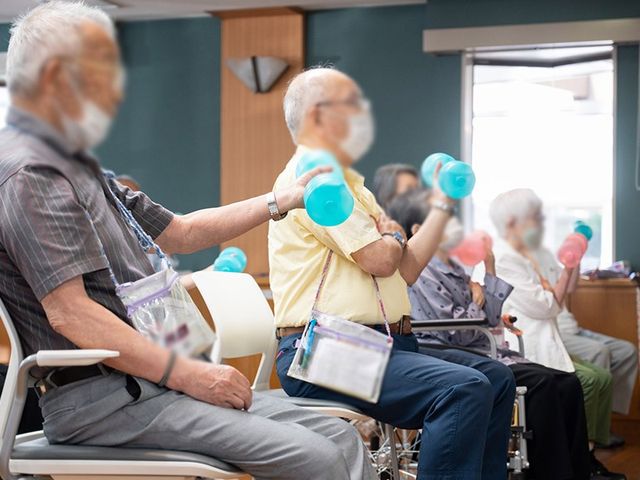 訓練するシニアの方々 機能訓練室 椅子に座って運動を楽しむ様子です。トレーニングを通じて健康づくりをサポートします。