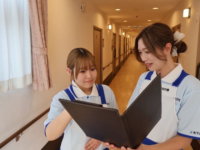 スタッフの廊下 廊下 明るい廊下でスタッフが書類を確認中です。連携しやすい快適な職場環境が整っています。