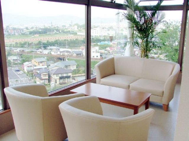 窓際の植物と椅子 談話コーナー 窓からの景色が楽しめる明るいラウンジです。やすらぎのひとときを過ごせる空間が提供されています。