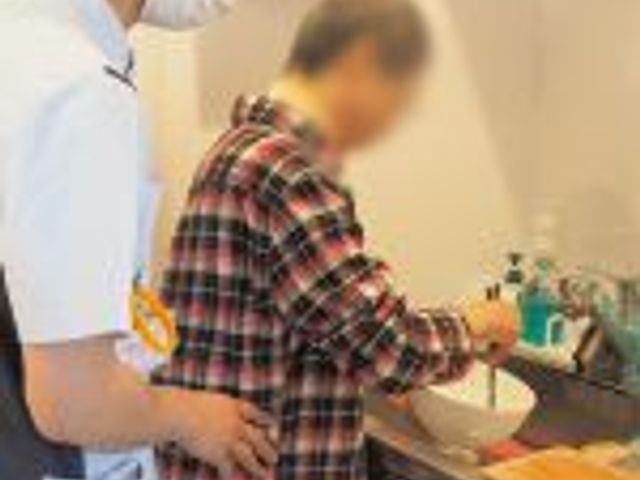 調理補助を受ける様子 キッチン スタッフが利用者の調理をサポートする姿が見られます。安心して働ける環境が整っています。