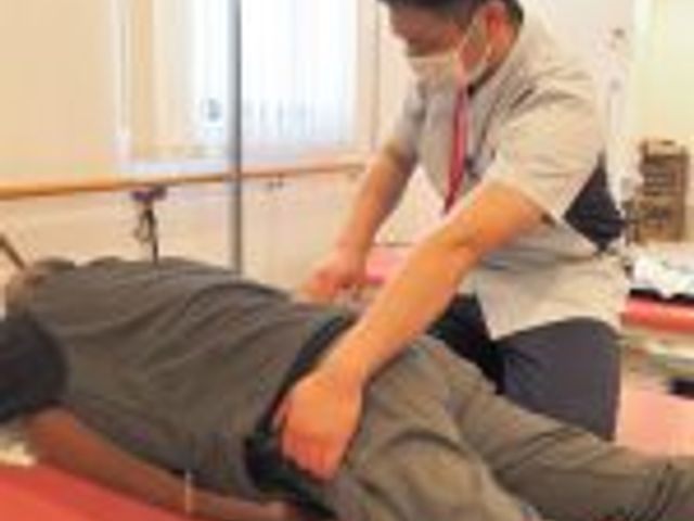 機能訓練の様子 機能訓練室 理学療法士が個別に指導する場面です。専門的なスキルを活かしてサポートする職場になります。
