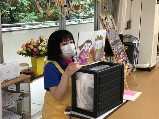 絵画を手にする笑顔の方