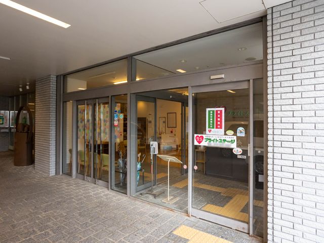 エントランスの自動扉 玄関 開放的なエントランスには気持ちを和ませる色彩の装飾があります。