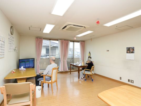 居室内でテレビを見る人々