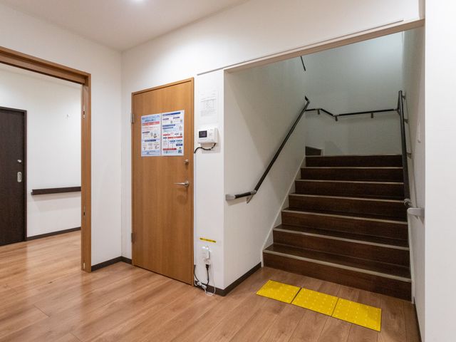 階段とドアの廊下 廊下 広々とした廊下に階段が続いており、アクセスしやすい環境です。配置された手すりが安全性を高めています。