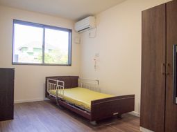 明るい居室のベッドと窓