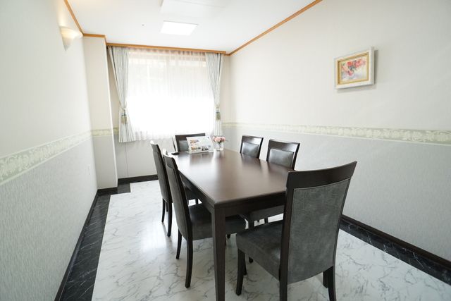 居室のダイニングテーブル 相談室 ゆとりある空間の居室で、ダイニングテーブルが配置され心地よい食事時間を提供しています。壁に飾られた絵画も温かみを演出しております。